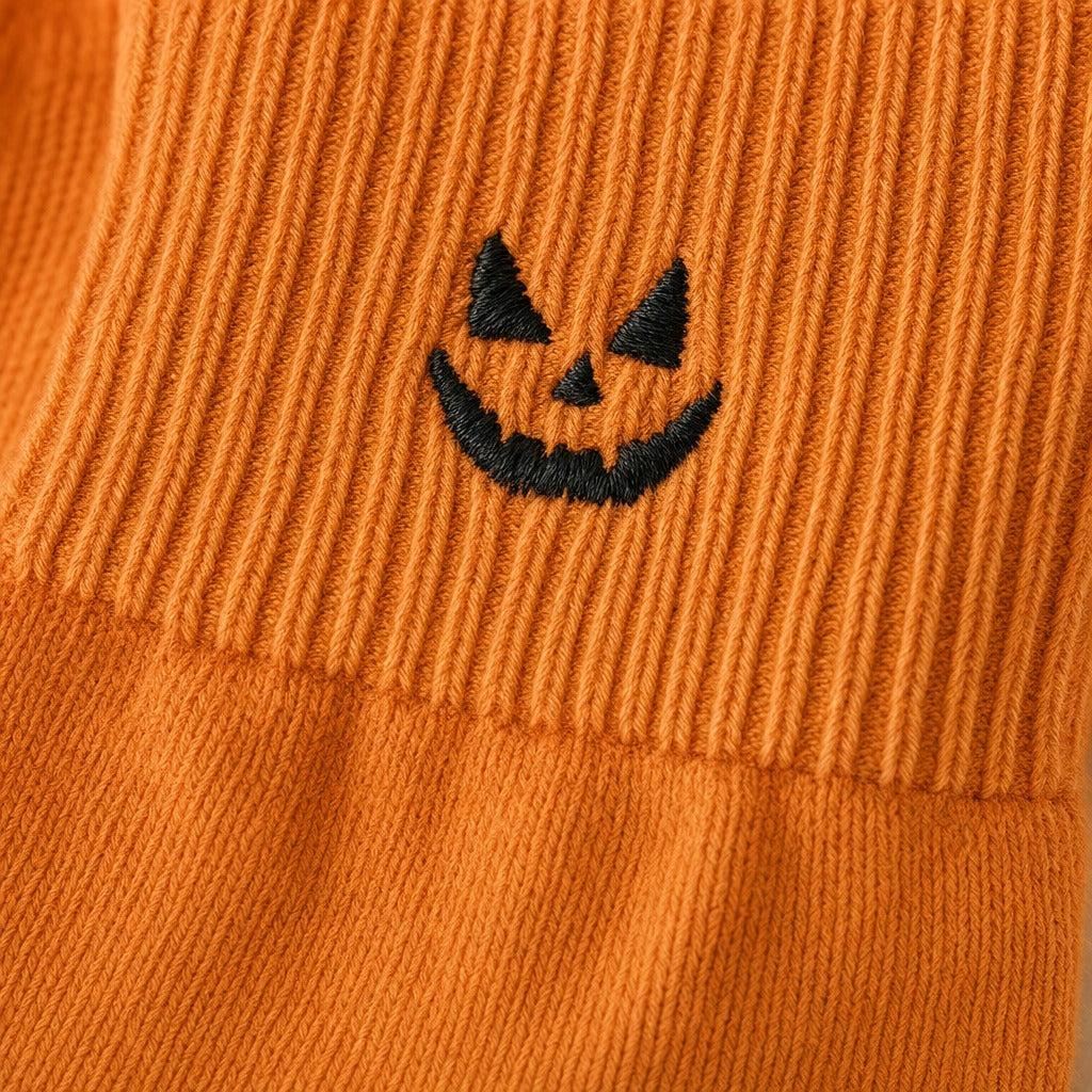 Macro of the embroidered pumpkin and ribbed cuff seam